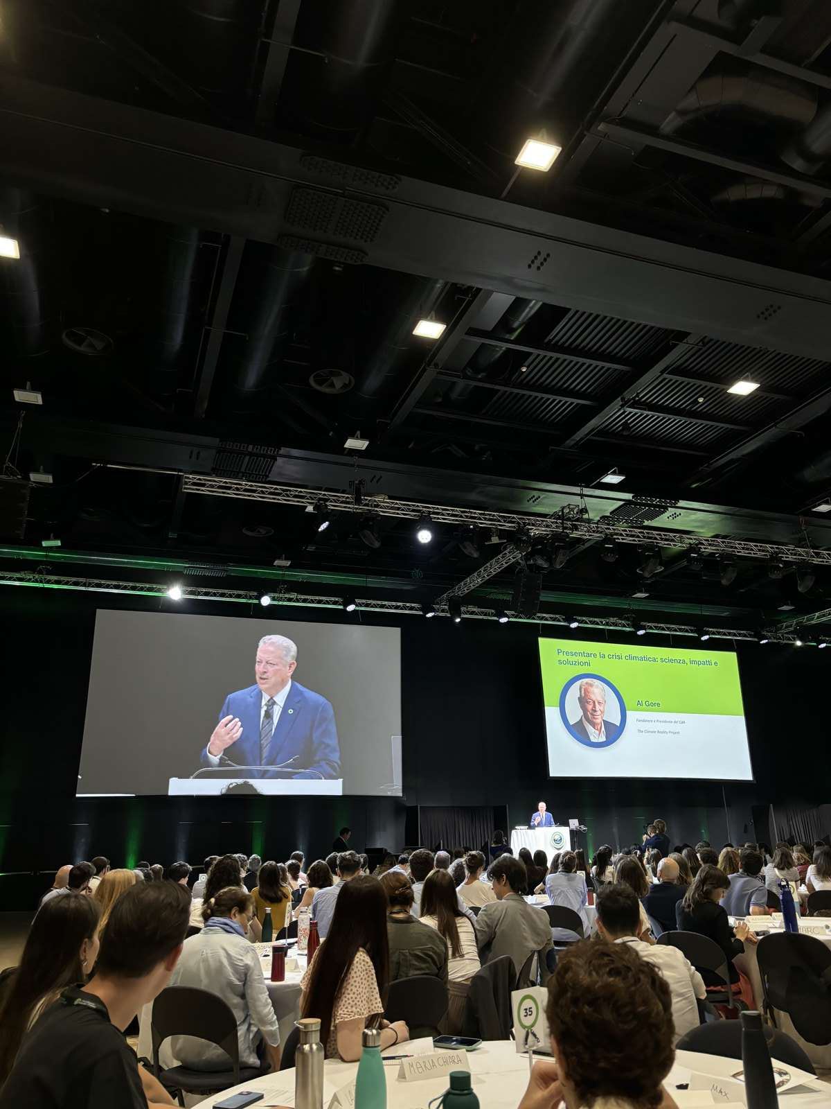 Al Gore speaking from the podium to a packed hall at the Climate Reality Leadership Corps training in Rome