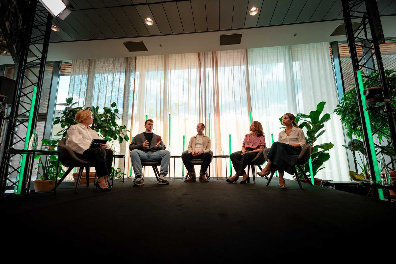 Five panellists seated against tall daylit windows during a Techarena Zero session in Stockholm