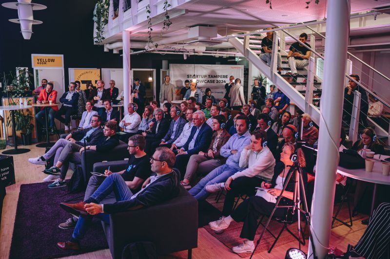Audience wearing translation headsets at the Startup Tampere Showcase 2024 inside the Platform6 co-working space
