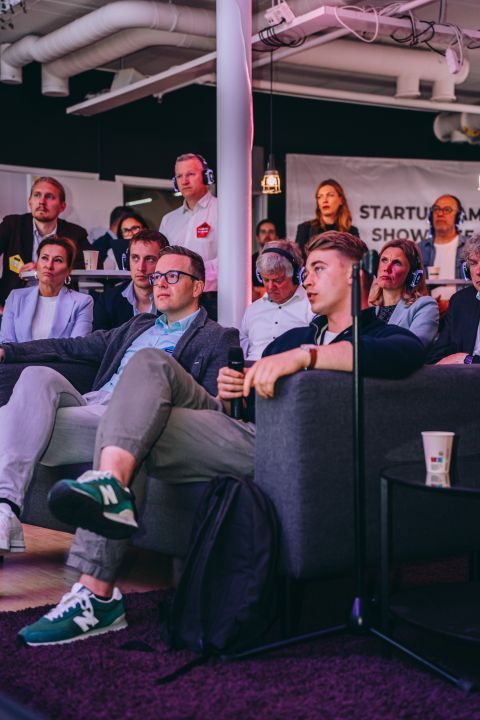 Attendees on sofas wearing translation headsets at the Startup Tampere Showcase 2024 in Tampere